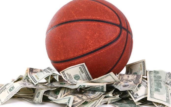 ballon de basketball au milieu d'un montagne de dollars