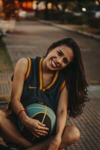jeune femme joyeuse avec un ballon de basketball entre les mains