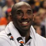 Kobe Bryant sur le banc de touche d'un match olympique, avec un large sourire sur les lèvres